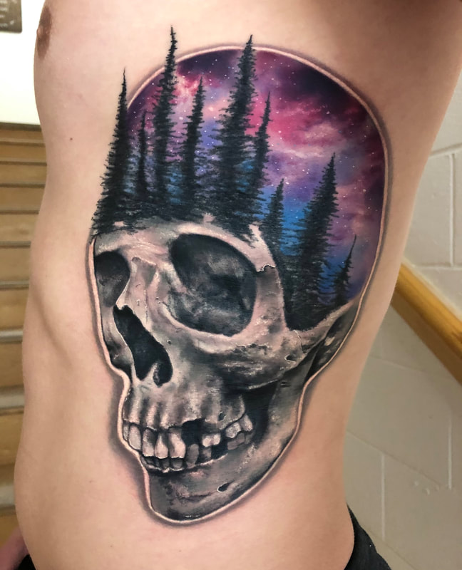 Realistic black and gray skull tattoo with trees and outer space in color.