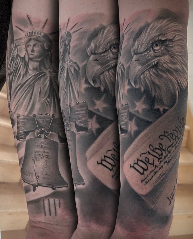 Black and grey realistic American tattoo with the Deceleration of Independence, Eagle, Liberty Bell, and Statue of Liberty arm sleeve.