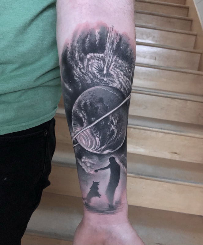 Black and grey space and planet forearm tattoo.
