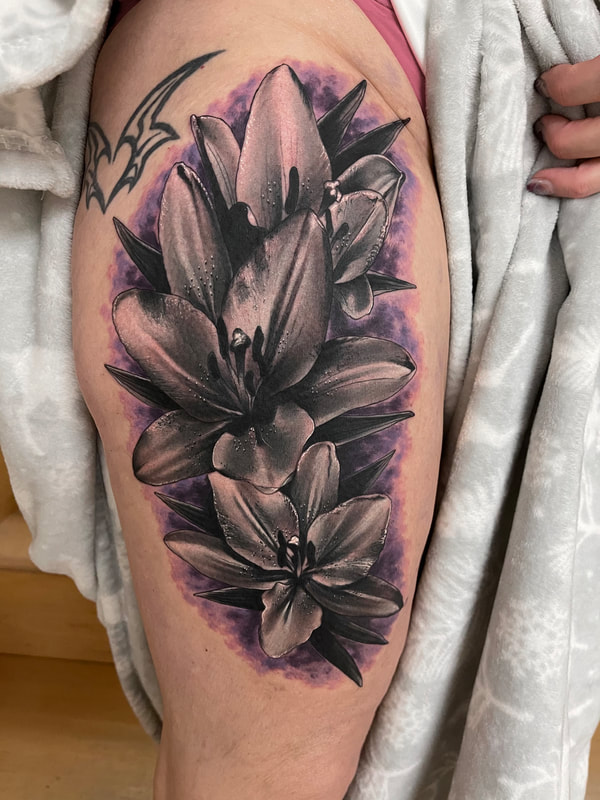 Realistic black and gray lilies thigh tattoo with purple background.