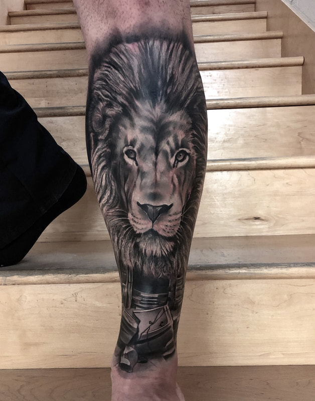 Realistic black and gray tattoo of Aslan from the movie Narnia.