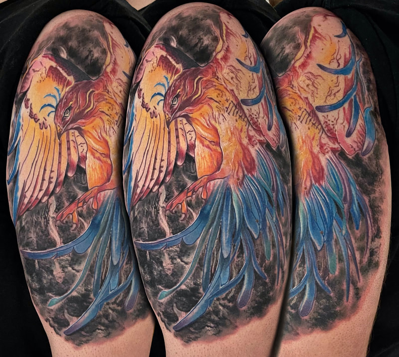 Color realism phoenix tattoo in red, orange, and blue with a grey background.