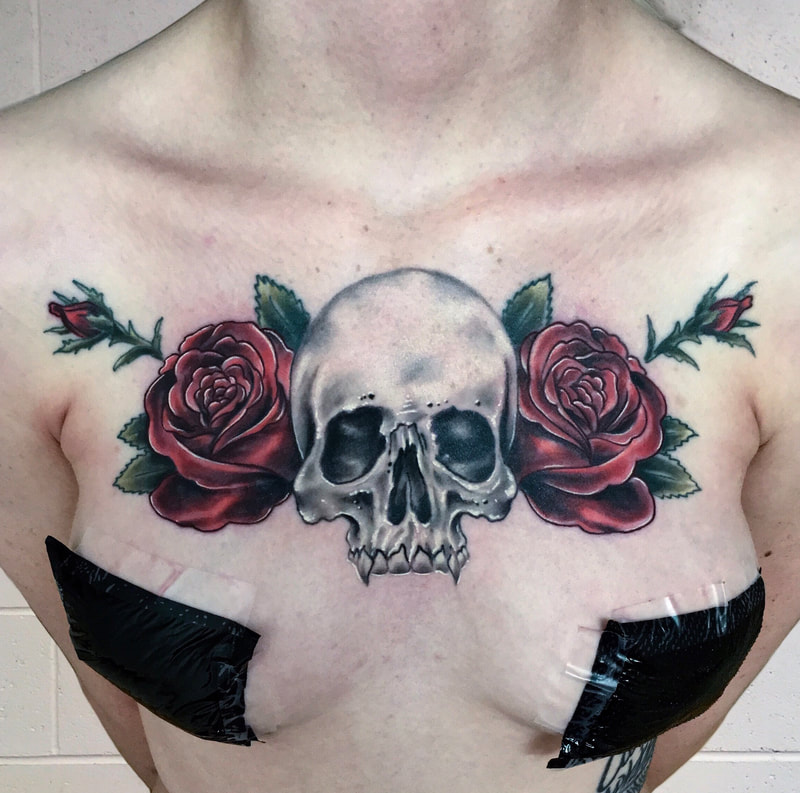 Black and grey realistic skull with red roses on a woman's chest.