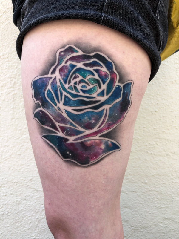 Negative rose tattoo with a galaxy color and grey background on a leg.