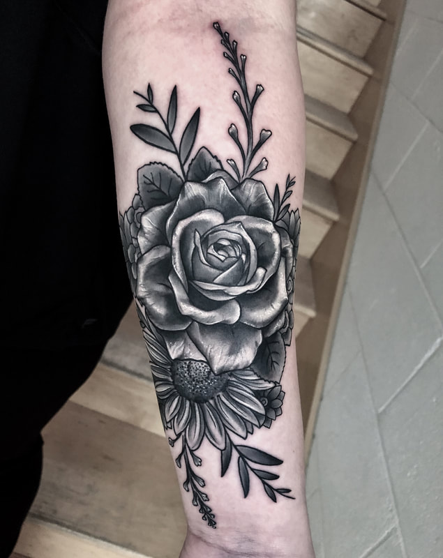 Realistic black and gray rose with mixed flowers forearm tattoo.
