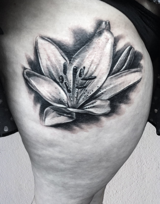 Realistic black and gray lily thigh tattoo.