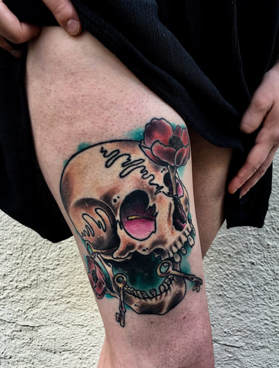 Neotraditional tan colored skull tattoo with keys in its mouth.