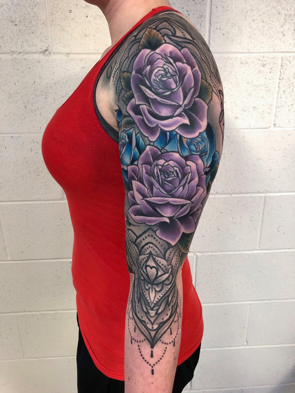 Color realism tattoo sleeve of purple and blue roses.