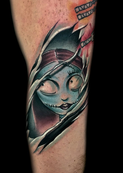 Colored Sally tattoo from the movie The Nightmare Before Christmas ripping through skin on an arm.